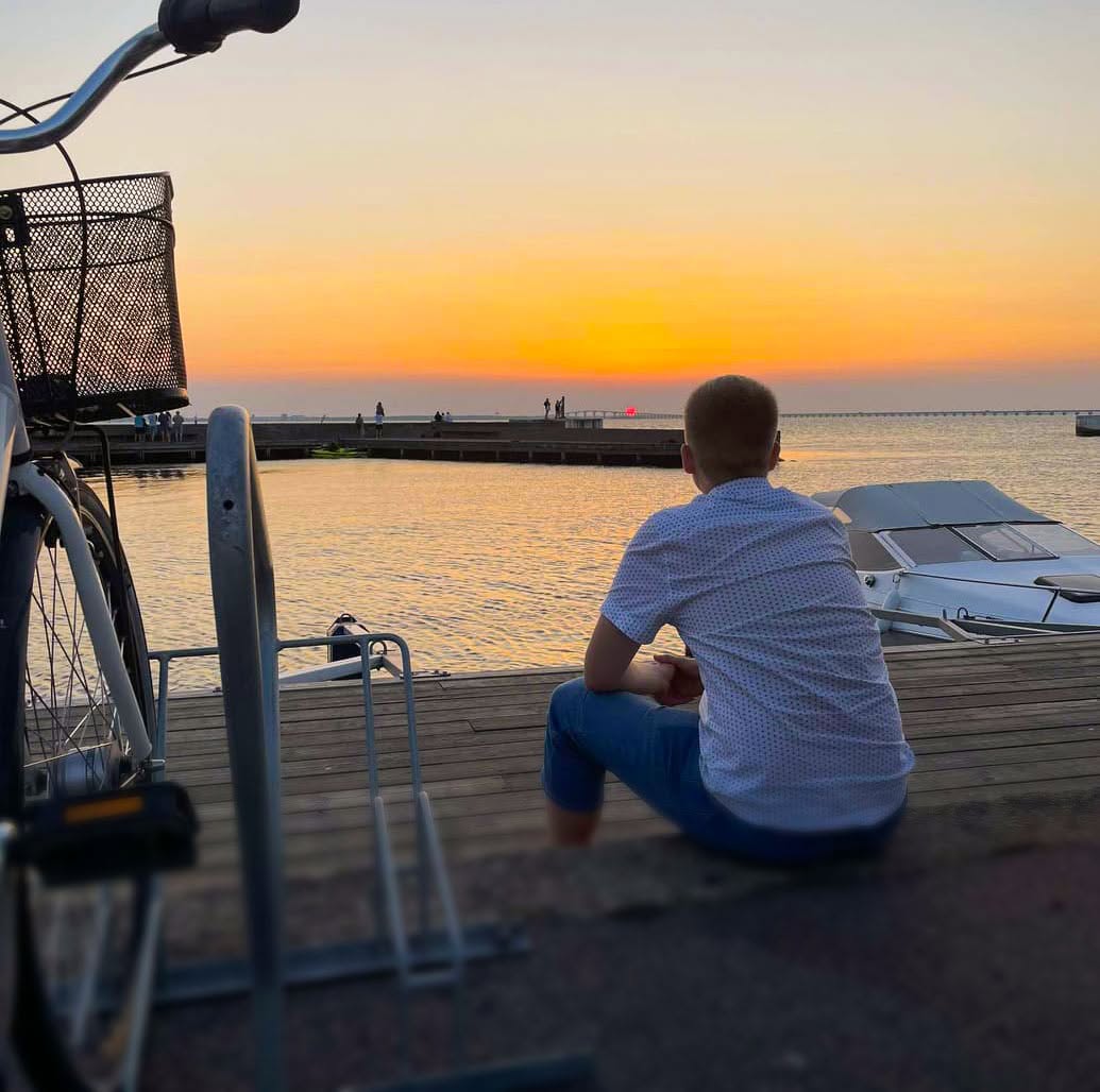 Gustaf Rossi blickar ut mot en solnedgång över Kalmarsund.